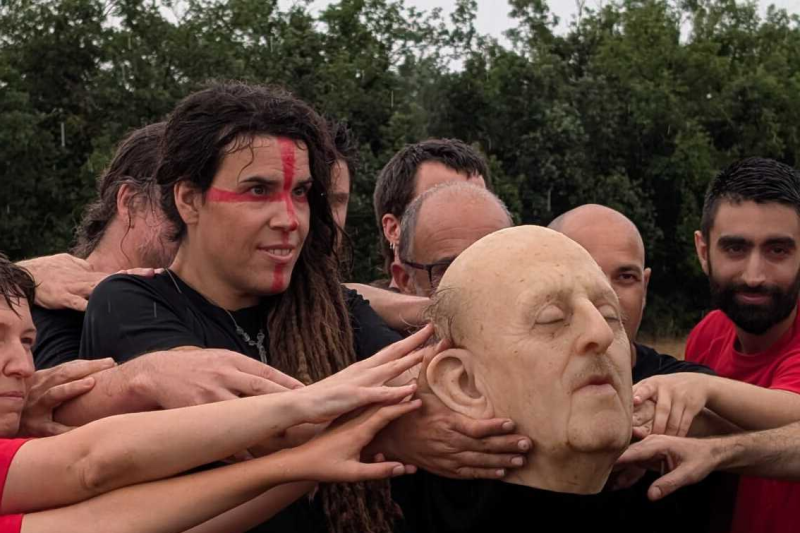 Jugadors i jugadores del partit artístic i reivindicatiu agafant el cap de Franco que ha fet de pilota. Imatge de Gemma Permanyer.