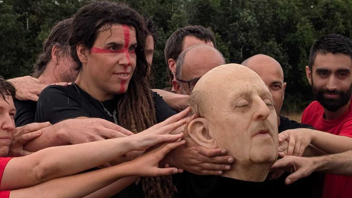 Jugadors i jugadores del partit artístic i reivindicatiu agafant el cap de Franco que ha fet de pilota. Imatge de Gemma Permanyer.
