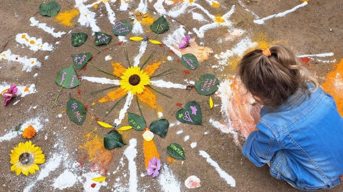es veu una nena participant en la creació del mandala